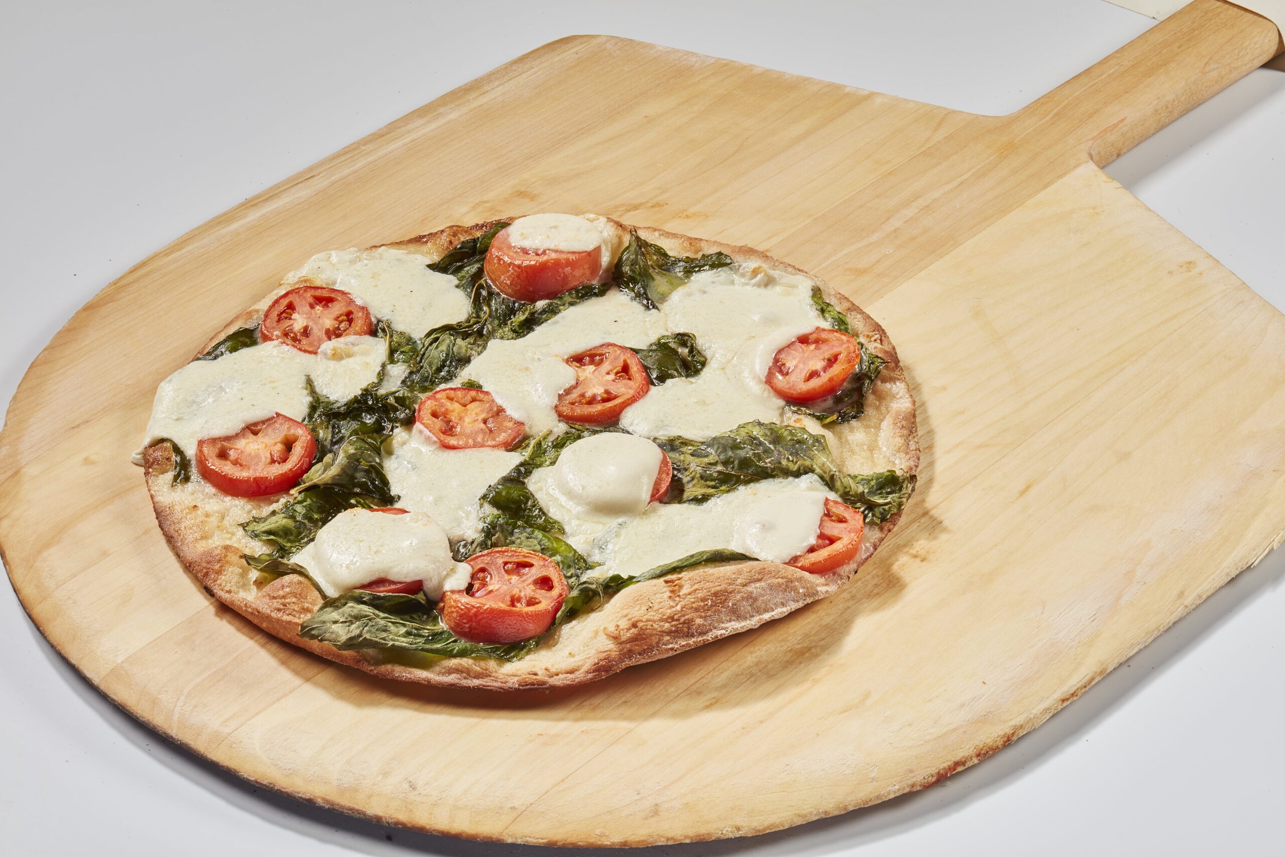 Margherita Pizza in Minneapolis with Mozzarella, Roma tomatoes, fresh basil, olive oil and garlic.